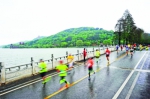 昨天，“汉马”遇上“倒春寒”，选手们不惧风雨，在东湖绿道上奔跑。记者苗剑 摄 - 新浪湖北