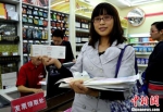 资料图：一位纳税人展示在超市刚领取的发票。中新社发 刘忠俊 摄 - 新浪湖北