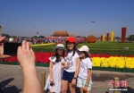 9月29日，三位小游客在北京天安门广场国庆花坛前留影。中新社记者 贾天勇 摄 - 新浪湖北