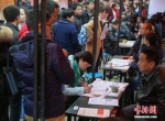 资料图：在武汉市纳杰人才市场招聘会上，挤满了前来应聘的求职者。中新社记者 张畅 摄 - 新浪湖北
