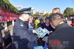 群众在宣传活动现场认真阅读民警发放的资料 张君 摄 - Hb.Chinanews.Com