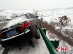 丹江口境内，雨雪导致路面湿滑，一辆轿车“骑”上护栏　程军　摄 - 新浪湖北