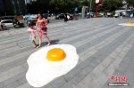 7月30日，数个巨型“煎蛋”模型“摊”在西安一商场门前，吸引过往行人注目。连日来，西安持续高温天气，最高气温超过40℃。中新社记者 张远 摄 - 新浪湖北