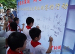 社区小志愿者们在文明公约签约墙上签名 - Hb.Chinanews.Com