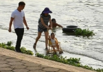 在汉阳晴川桥下，一位女士推着童车在汉江亲水平台上散步，享受清凉的江水。记者金思柳 摄 - 新浪湖北