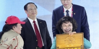 10月13日，中国残奥委主席、中国代表团团长张海迪（右前）展示印尼残奥委会主席森尼·马尔伯恩赠送的礼物 - 残疾人联合会