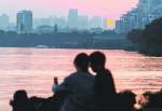 11月27日，夕阳西下，在东湖绿道旁的草地上，一对情侣在夕阳的映照下拿着手机自拍记者肖僖 摄 - 新浪湖北