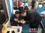 王冠雄正在为重点旅客核对车票（田学睿 摄） - Hb.Chinanews.Com