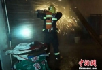 消防员利用无齿锯将卷帘门破拆　刘芳琳　摄 - 新浪湖北