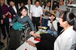图为张海迪与用脚剪剪纸、做绢花的残疾人亲切交谈 - 残疾人联合会