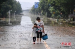 连日来，衡东县出现了持续强降雨天气，造成该县17个乡镇、233个村、22个社区普遍受灾。图为两位村民在东健大道上折返回家。（资料图片）杨华峰 摄 - 新浪湖北