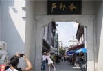 8月14日，武汉户部巷小吃一条街，外地游客在巷口留影。 - 新浪湖北