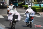 资料图：市民穿戴遮阳防晒装备在高温天气出行。中新社记者 张勇 摄 - 新浪湖北