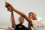 这是2012年5月18日，残疾人飞镖运动员曲显光（右）在训练中。新华社记者王凯摄 - 残疾人联合会