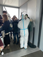 1月21日，杭州萧山机场里的工作人员为武汉飞来航班的乘客挨个量体温。 受访者供图 - 新浪湖北