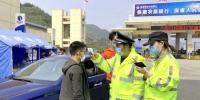 民警正在审验过境旅客信息、测量体温。 - Hb.Chinanews.Com