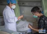 6月17日，医生朱琦在病房指导胡定江进行恢复训练。新华社记者 肖艺九 摄 - 新浪湖北