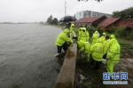 沙洋县公安民警紧急出动加固加高长湖岸堤。新华网发 赵平摄 - 新浪湖北