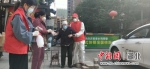 2020年3月，朱雄飞(右)在社区下沉时搀扶行动不便的老人 - Hb.Chinanews.Com