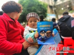 宣讲会上小孩拿着宣传手册 文方举供图 - Hb.Chinanews.Com