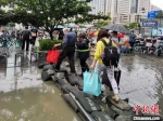 地铁工作人员在站外出入口积水处利用沙袋垒砌防滑步道确保乘客正常通行 武汉地铁供图 - 新浪湖北