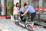 工作人员在查验程女士的电动自行车。 - Hb.Chinanews.Com