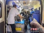 武警官兵帮助医护人员将伤者抬上救护车 - Hb.Chinanews.Com