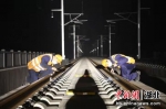 图为两位高铁打磨师夜间检查打磨后的线路质量（杨黎君 摄） - Hb.Chinanews.Com