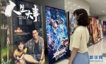 7月4日，一位观众在武汉中影烽禾影城浏览电影海报。新华网发 张严溢摄 - 新浪湖北
