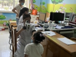 图为新洲区妇幼保健院医生为儿童做视力检查 - 残疾人联合会