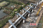11月22日，一列高铁列车经过完成吊装后的钢盖梁(无人机照片)。雷佳民摄 - Hb.Chinanews.Com
