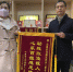 图为林惜梅（左）向区残联理事长王毅（右）捐赠锦旗 - 残疾人联合会