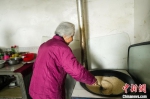 图为102岁的鞠兰英老人正在炒制当地特色食品米茶。中新社记者吴淘淘摄 - Hb.Chinanews.Com